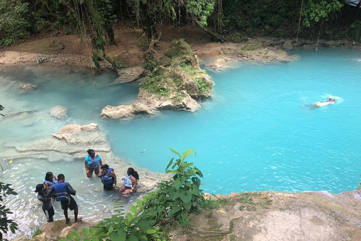 un gruppo di persone in piedi in una piscina di acqua blu