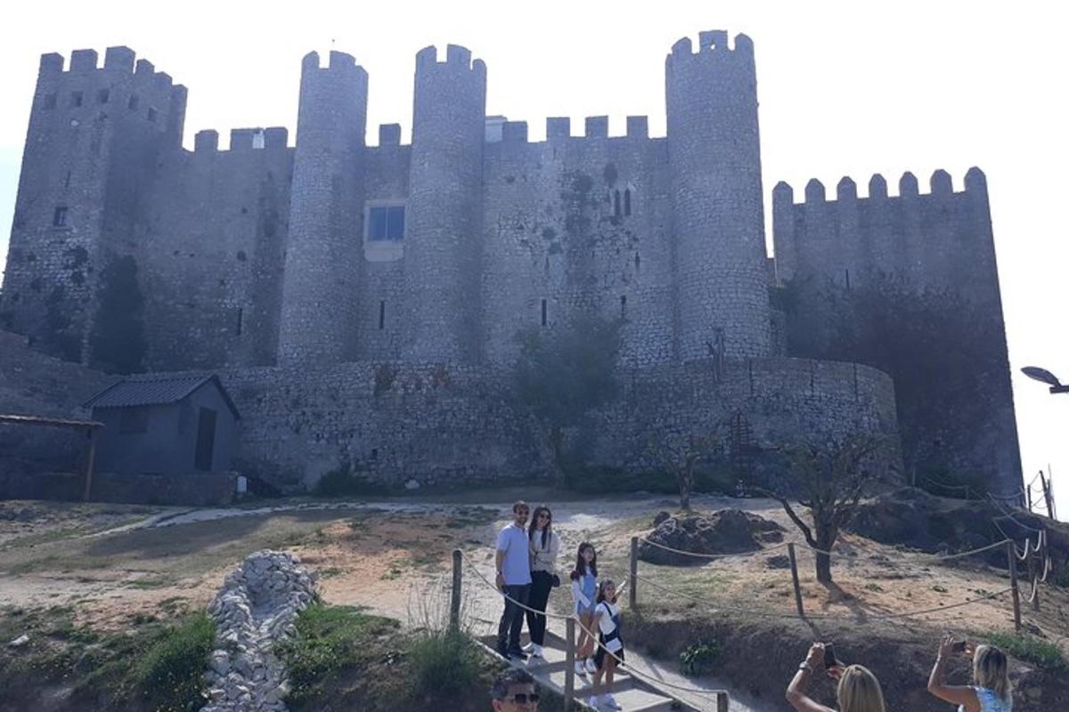 un grup de oameni care stau în fața unui castel