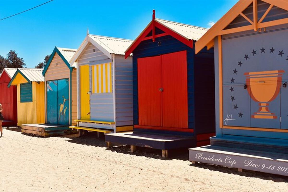 una filera de casetes de platja de colors a la platja