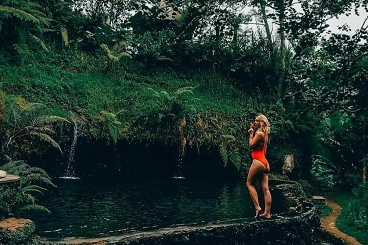 een vrouw die in het water staat en op een mobiele telefoon praat