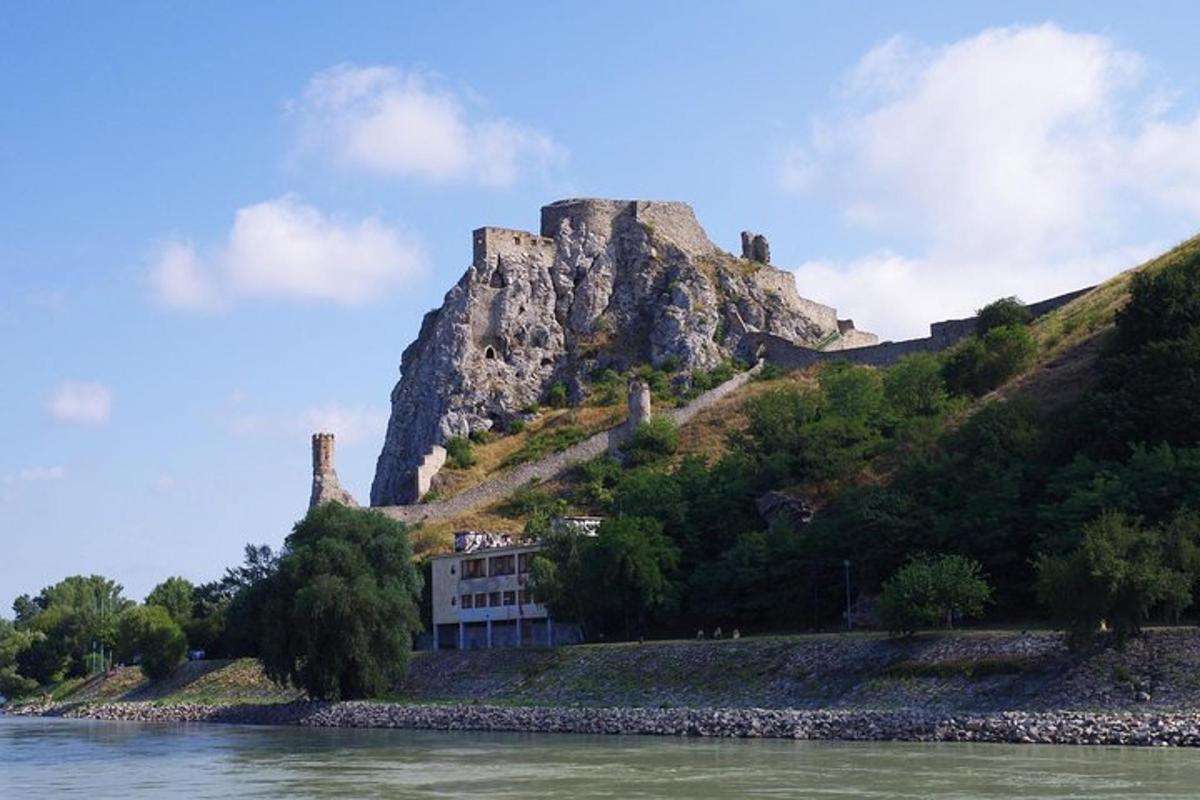 un castello in cima a una montagna vicino all'acqua