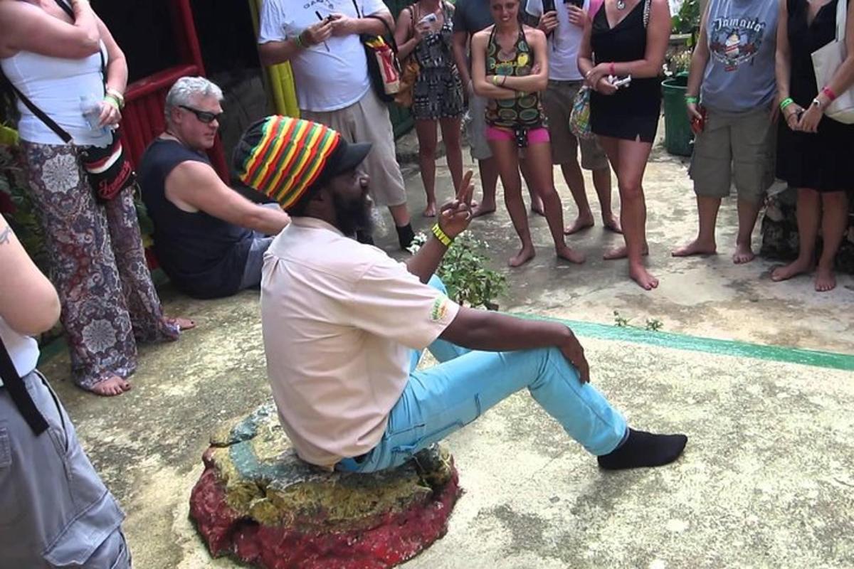 a man sitting on a rock with a hat on his head