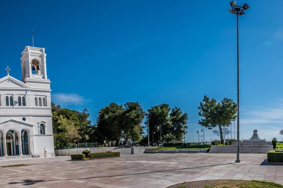 um edifício branco com uma torre de relógio em um parque