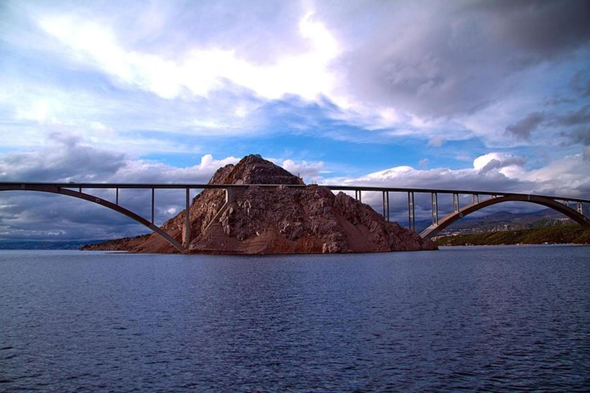 un ponte sopra un grande specchio d'acqua con una montagna