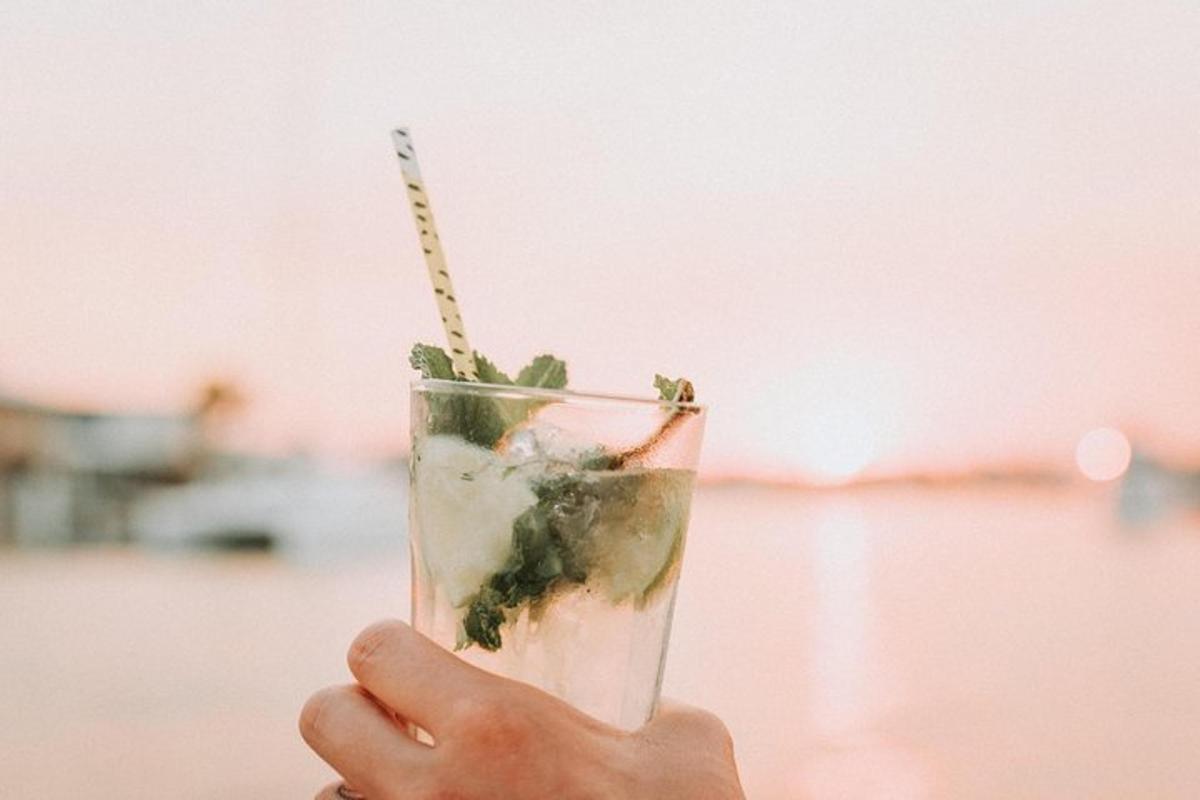 a hand holding a drink with a straw