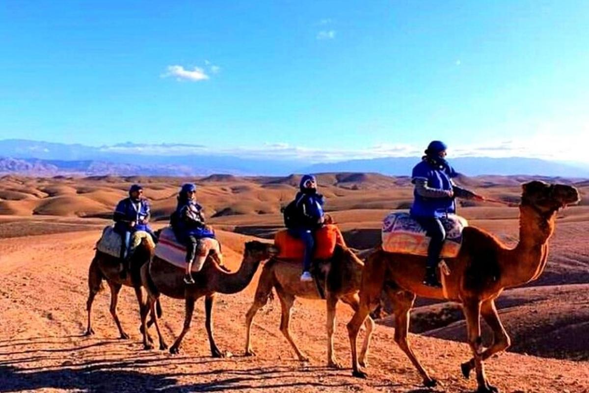 Un grupo de personas montando camellos en el desierto.