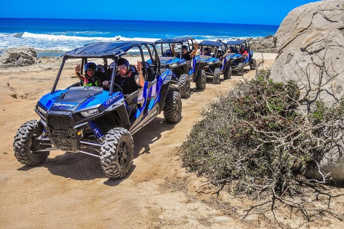 um grupo de pessoas andando de quadriciclo em uma praia