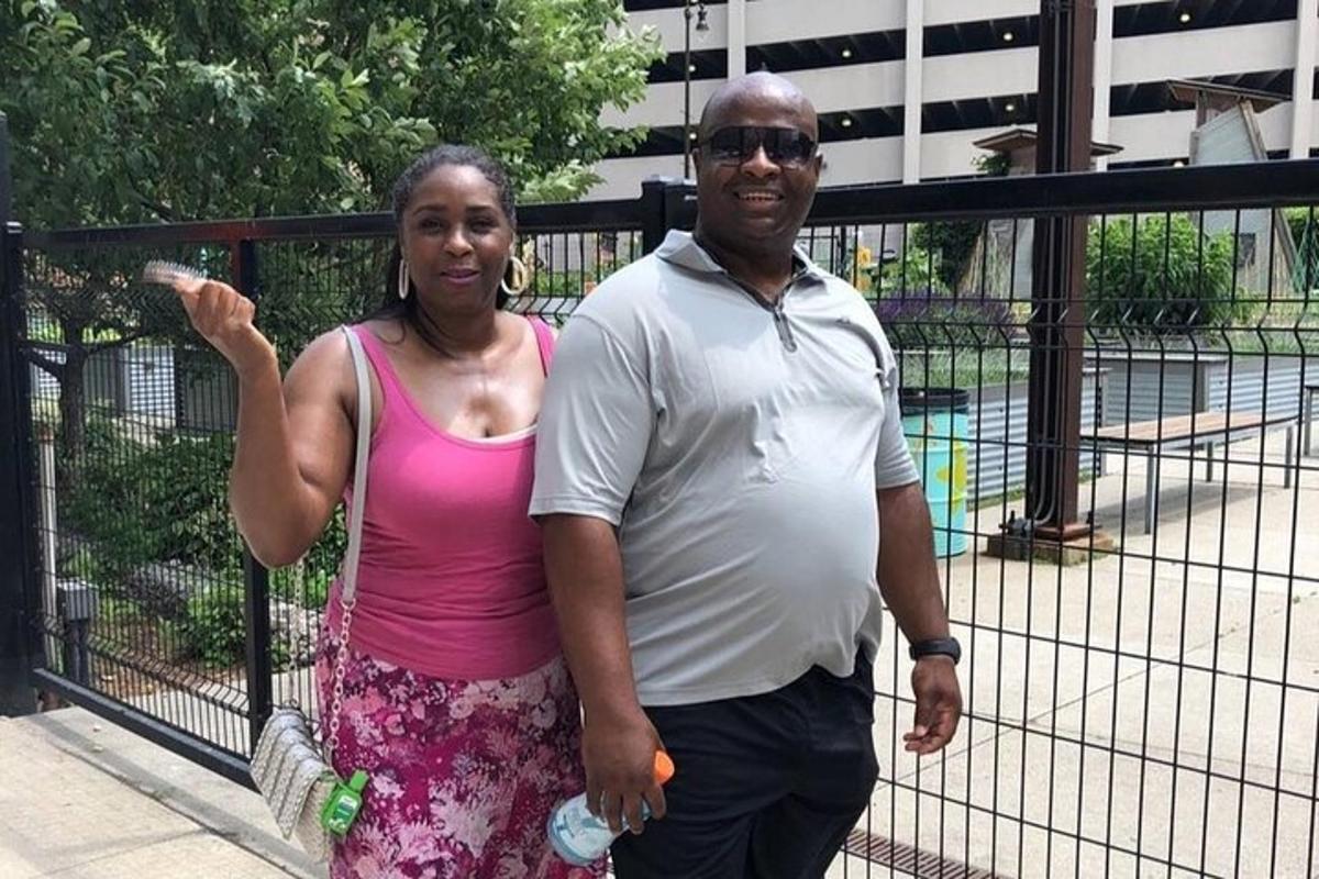 a man and a woman standing next to a fence