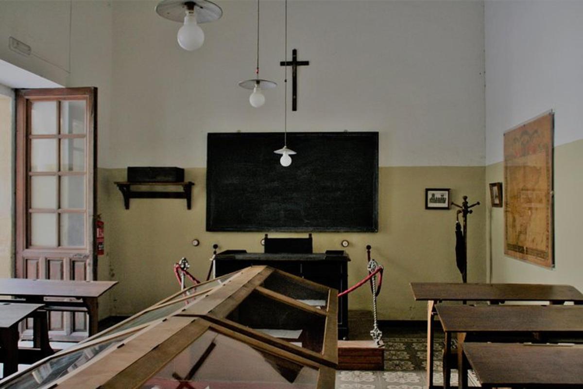 un'aula con una lavagna e una croce sul muro