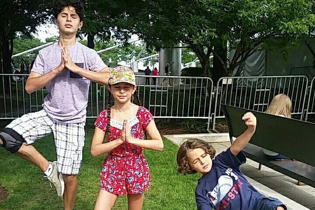 a man and two children standing in the grass
