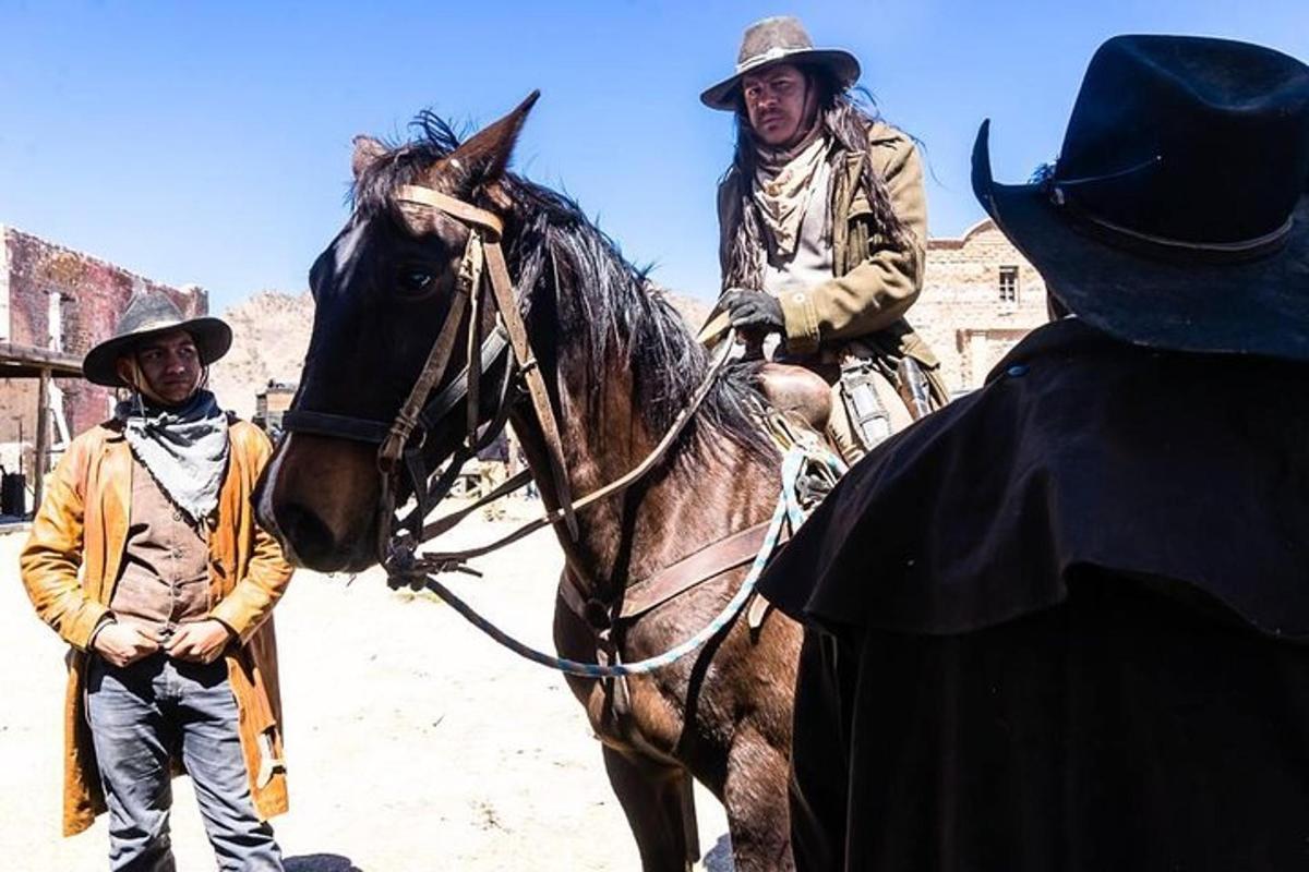 two men are riding a horse in the desert