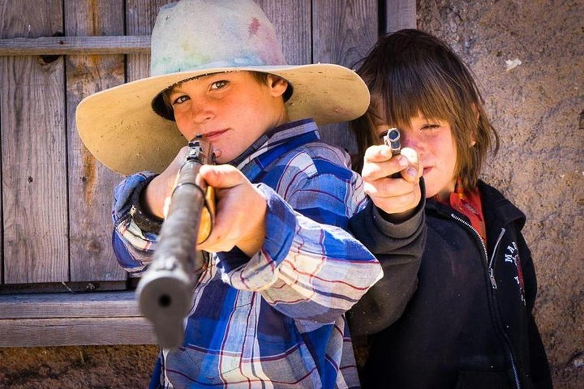 a young boy in a cowboy hat playing instruments