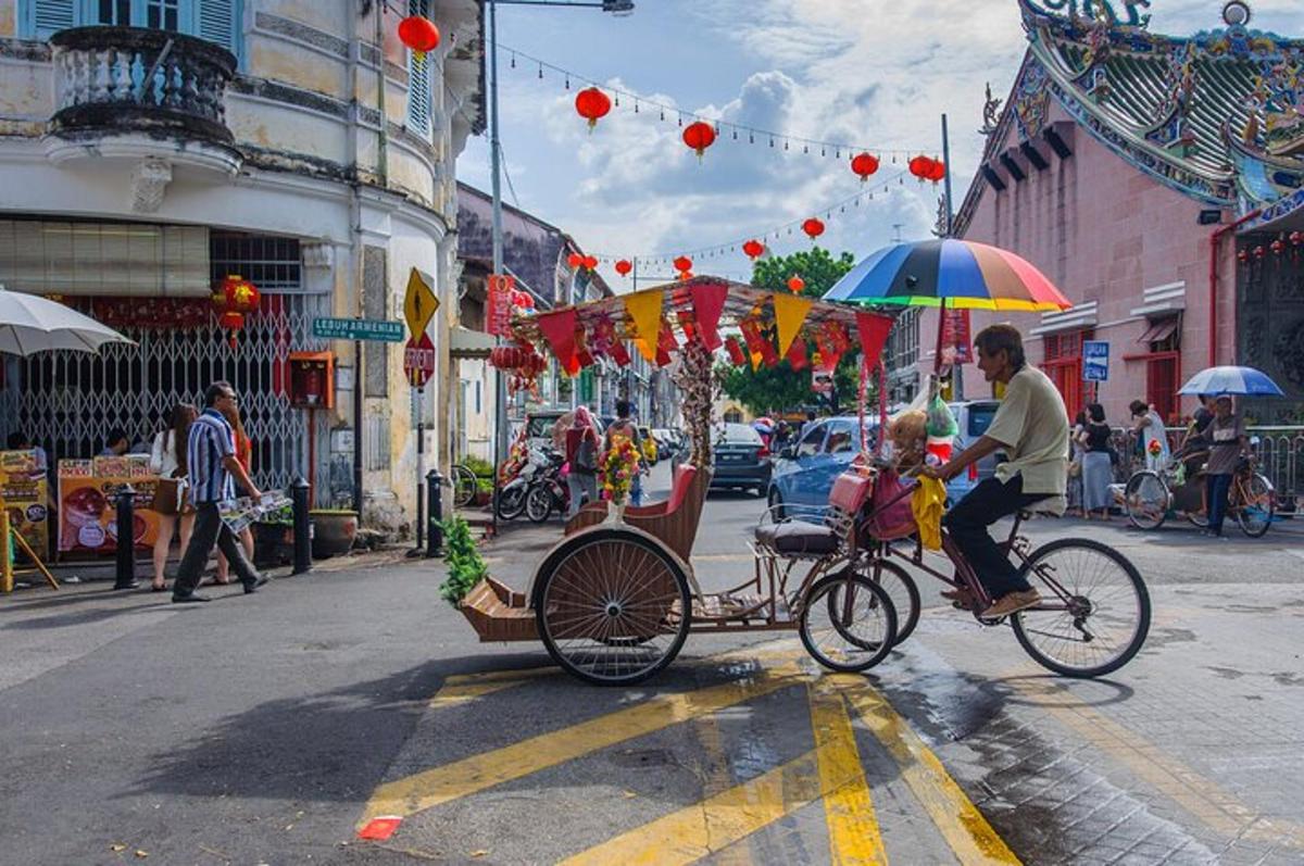 a man riding a bike with a child in a cart with an umbrella