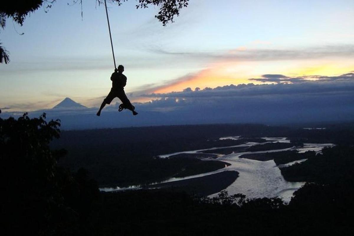 a person on a rope swing over a river