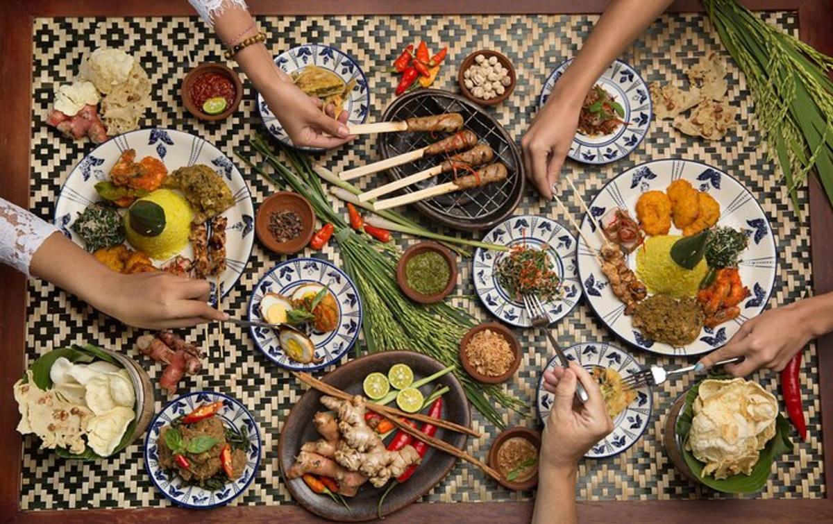 a group of people standing around a table with plates of food