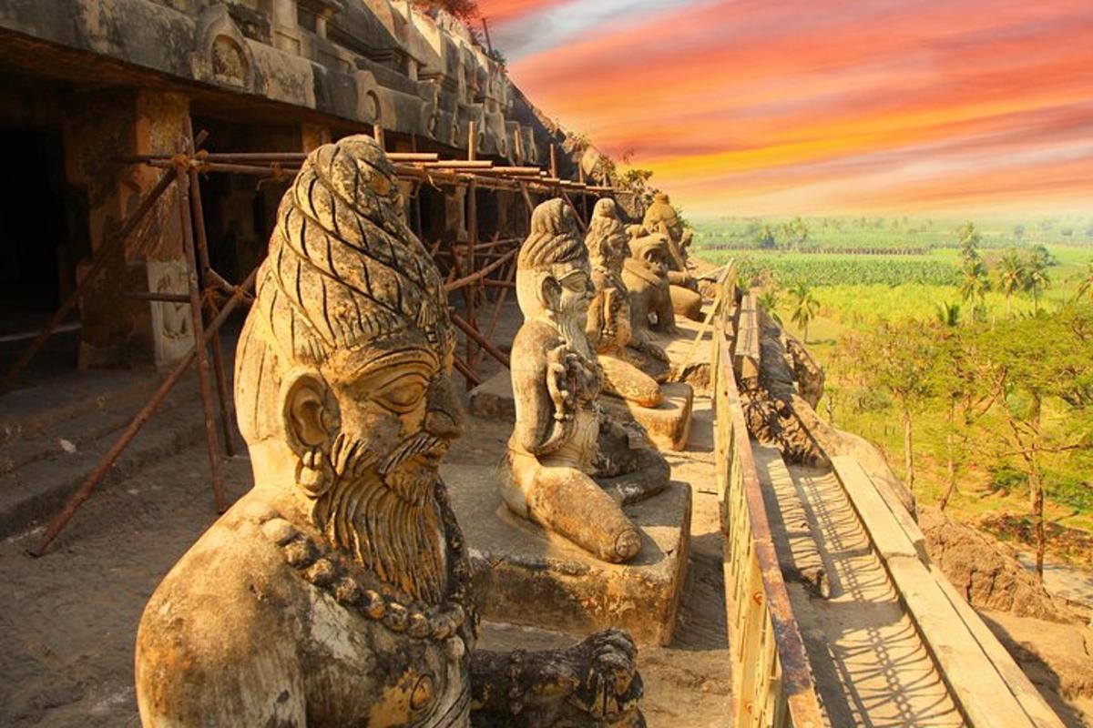 a row of stone statues standing next to a building