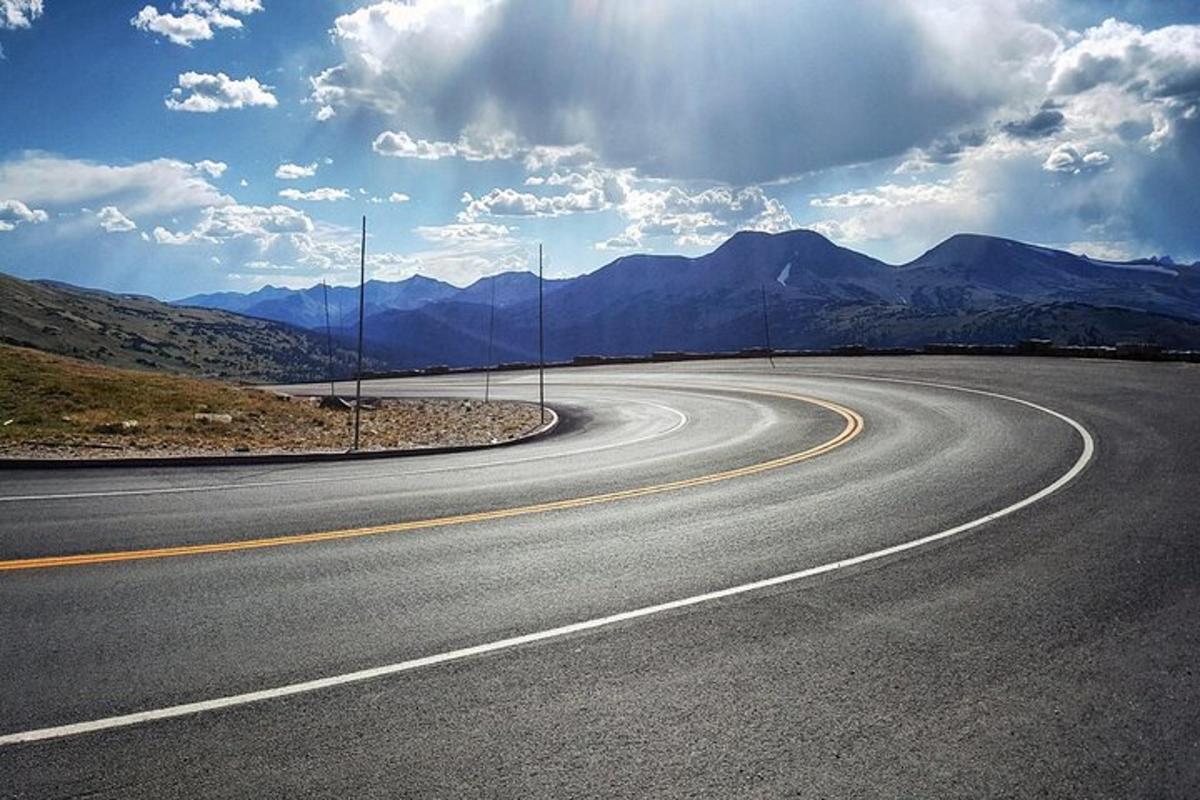 an empty road with mountains in the background