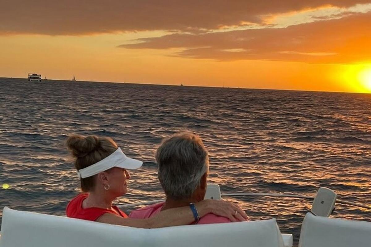 Un hombre y una mujer sentados en sillas mirando la puesta de sol