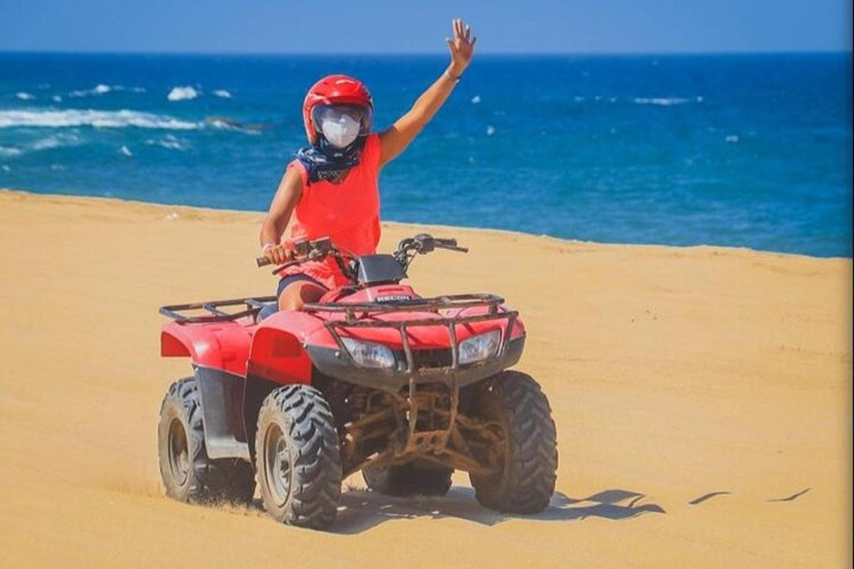 una persona que viaja en un vehículo de cuatro ruedas en la playa