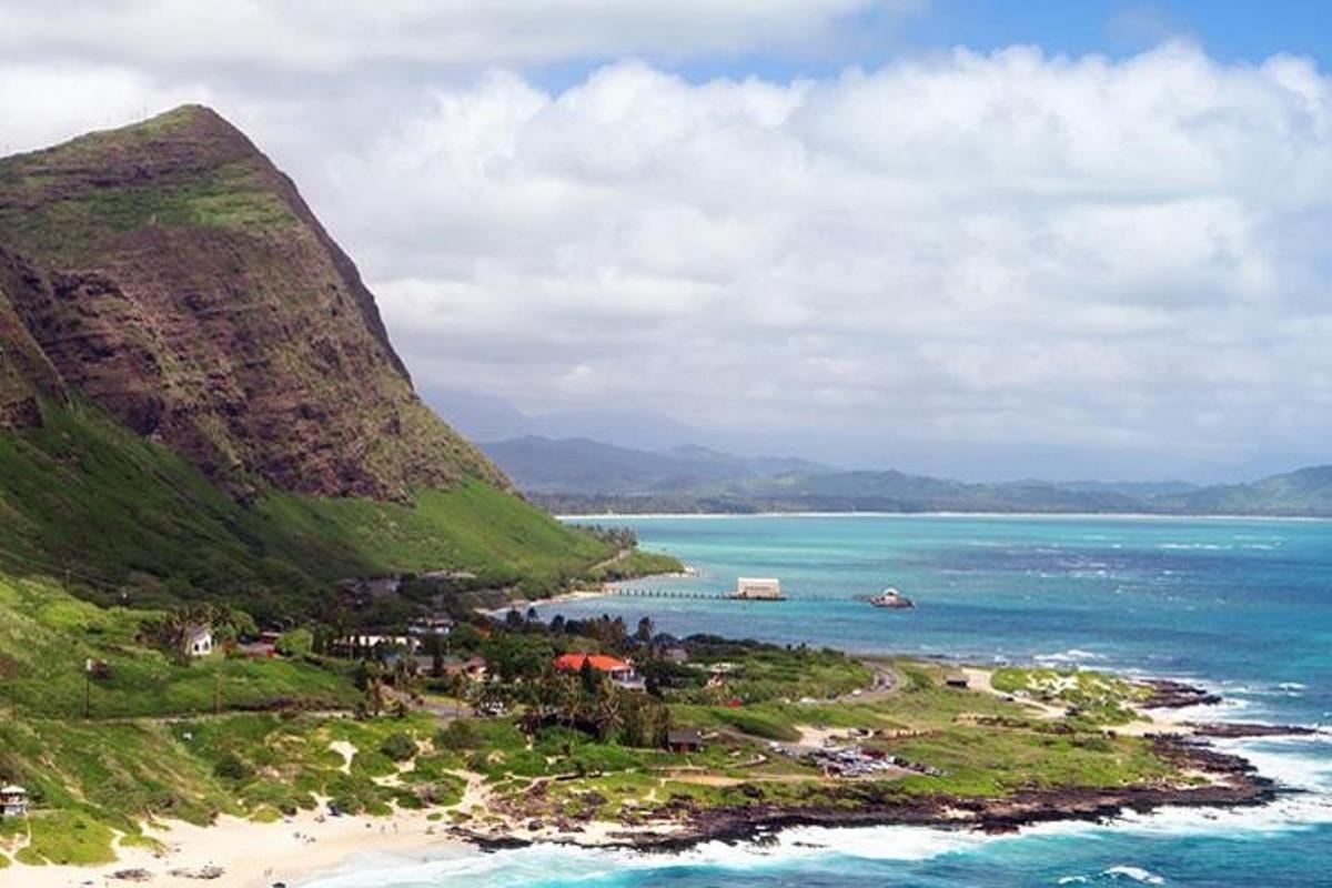 an island in the ocean next to a mountain