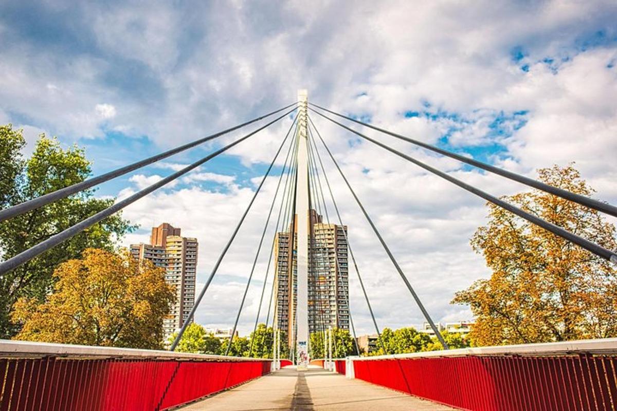 uma ponte vermelha com uma cidade ao fundo