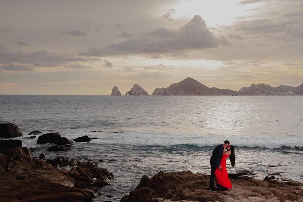 pasangan pengantin berdiri di atas batu berhampiran lautan