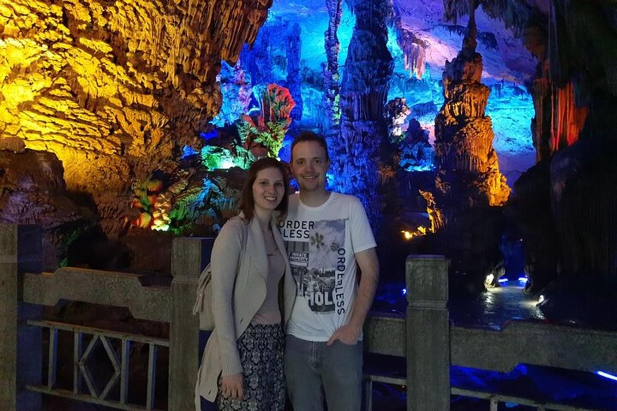 a man and a woman standing in front of a cave