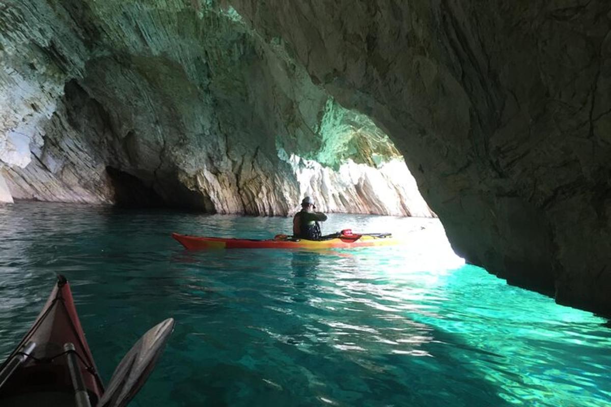 особа у кајаку у пећини у води