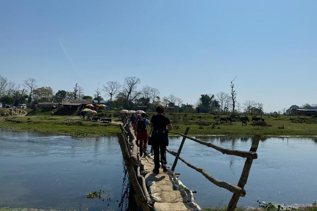 un gruppo di persone che attraversa un ponte su un fiume