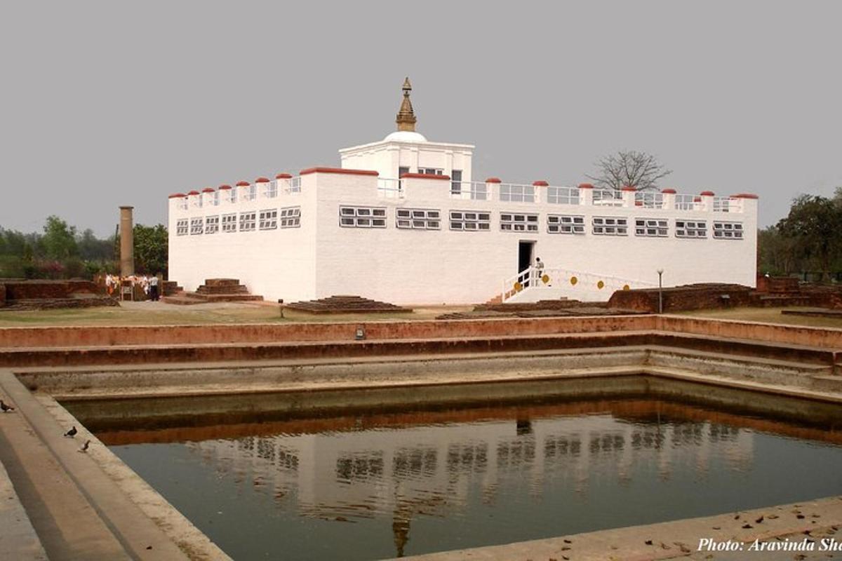 a large white building in front of a pool of water