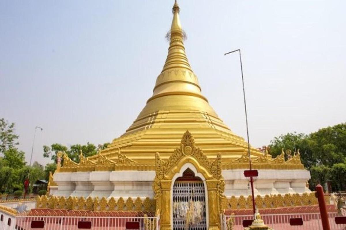a large golden pagoda with a gate in front