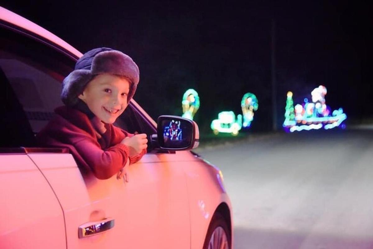 a young child looking at a side view mirror of a car
