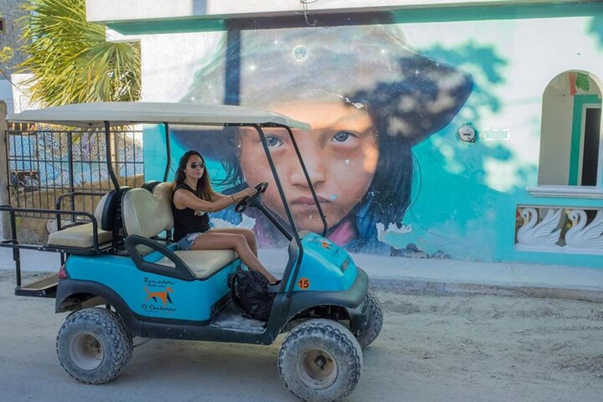 une fille conduisant une voiturette de golf devant une fresque murale