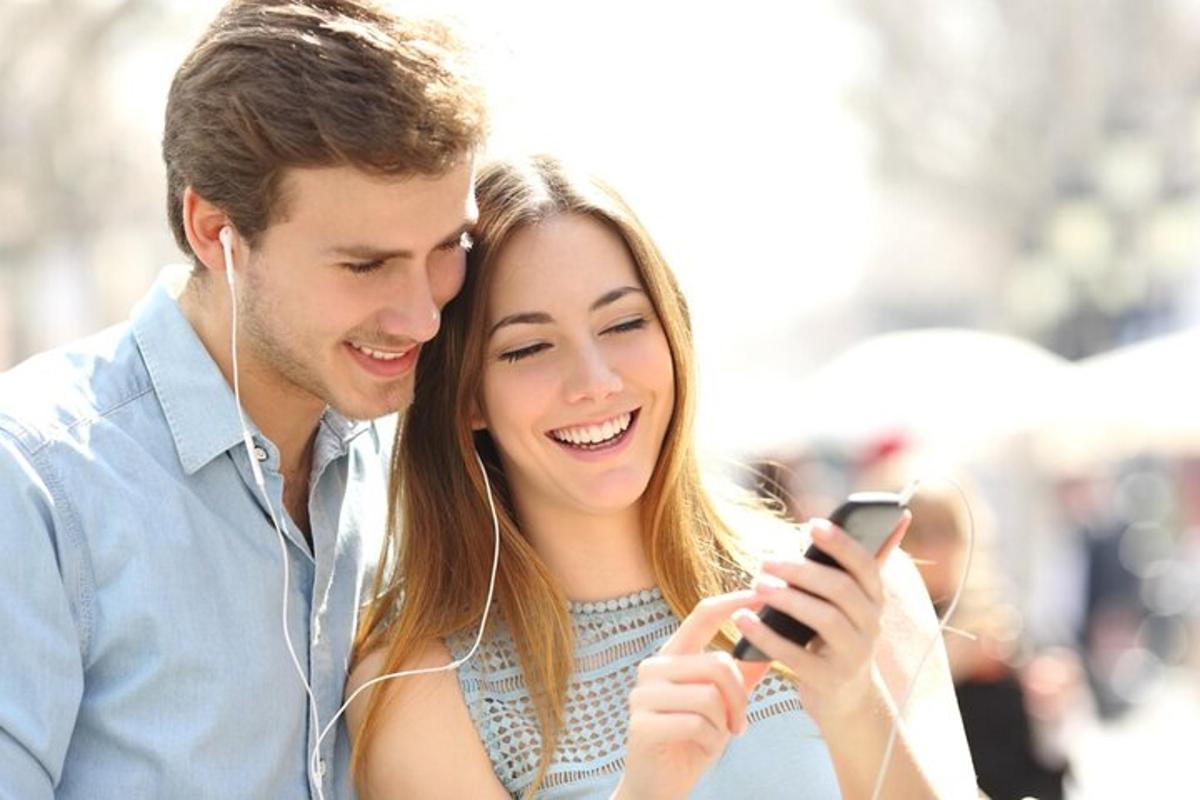 vyras ir moteris žiūri į mobilųjį telefoną