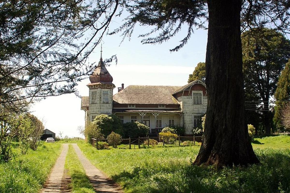 an old house with a clock tower in a field