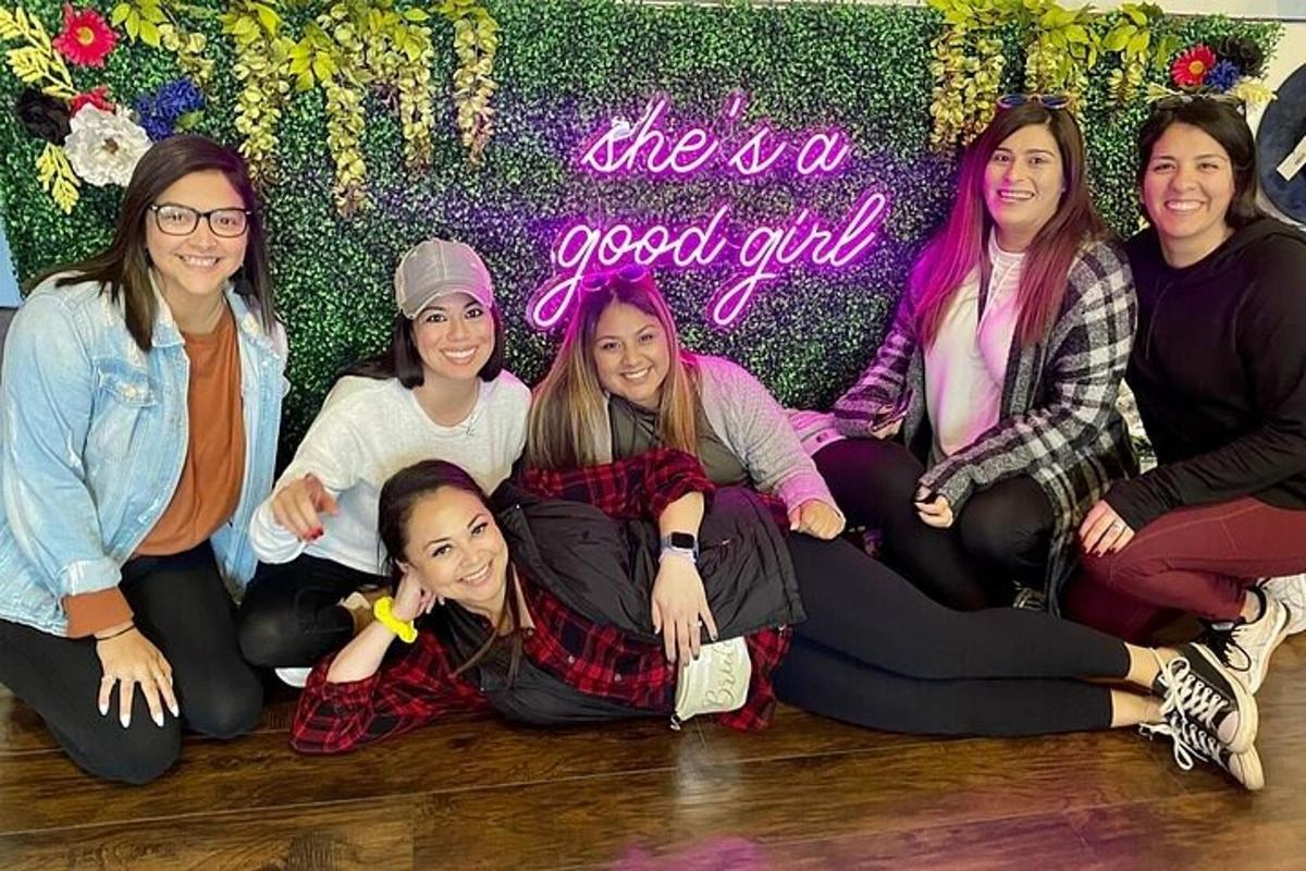 a group of girls sitting on the floor in front of a wall