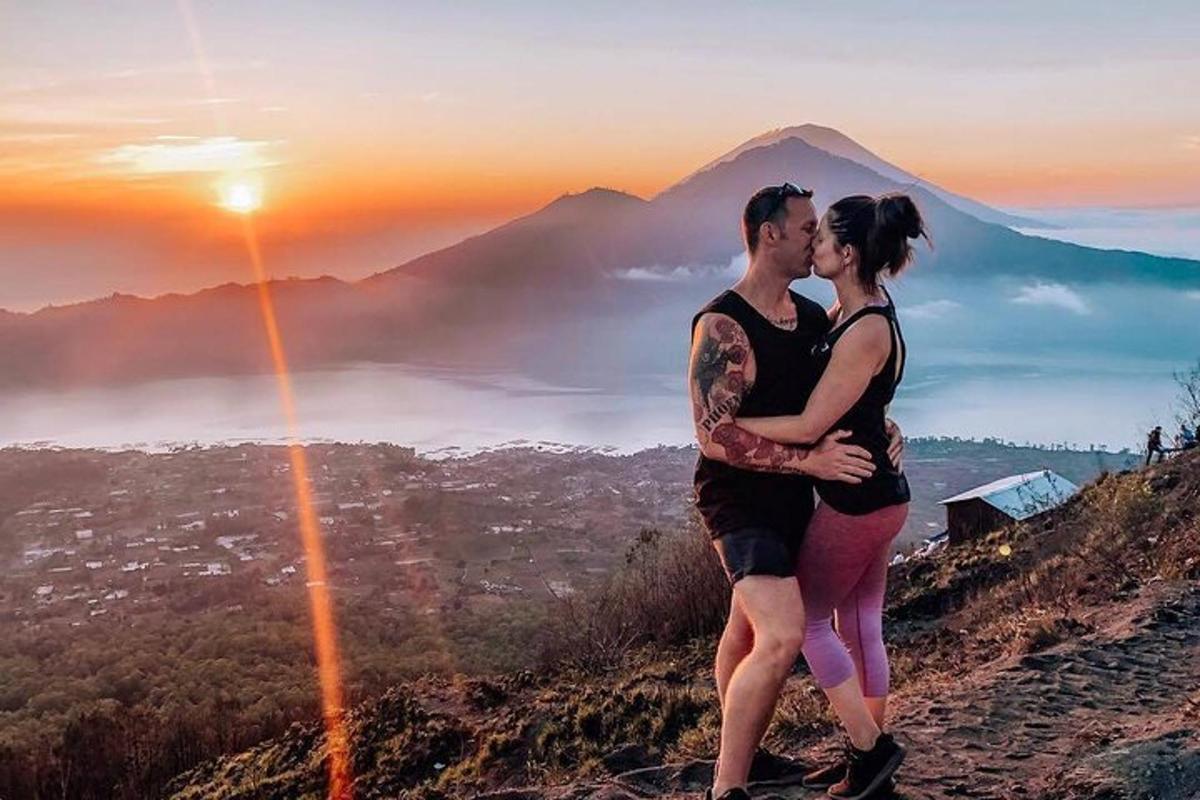un uomo e una donna in piedi sulla cima di una montagna