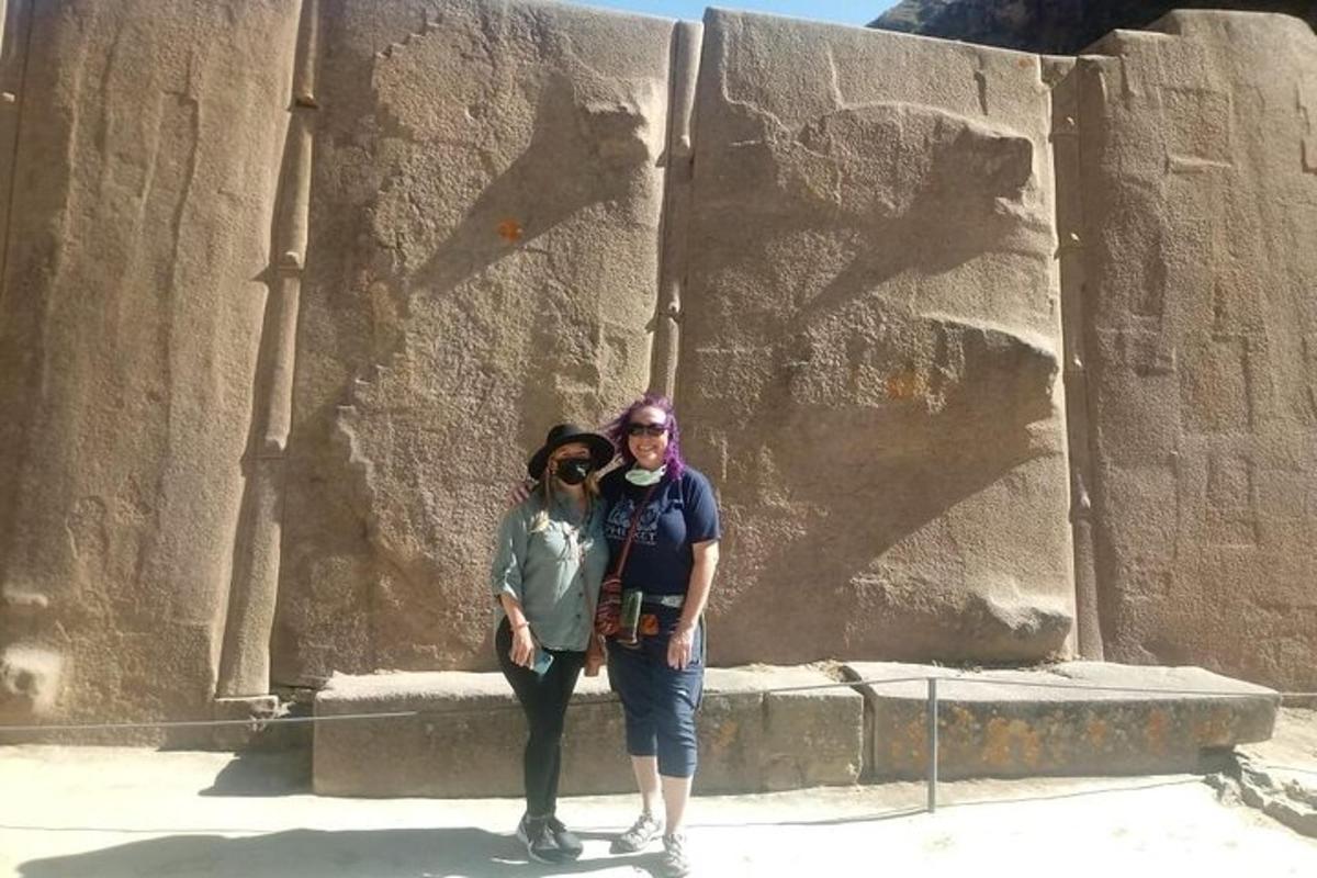 Un hombre y una mujer de pie frente a un muro de piedra.