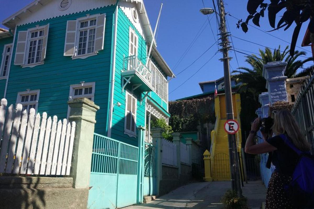 a woman taking a picture of a colorful house