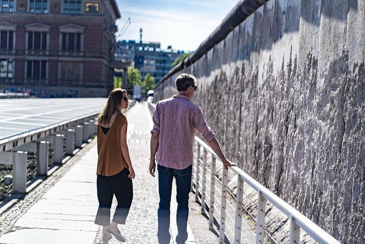 un uomo e una donna che camminano lungo un muro