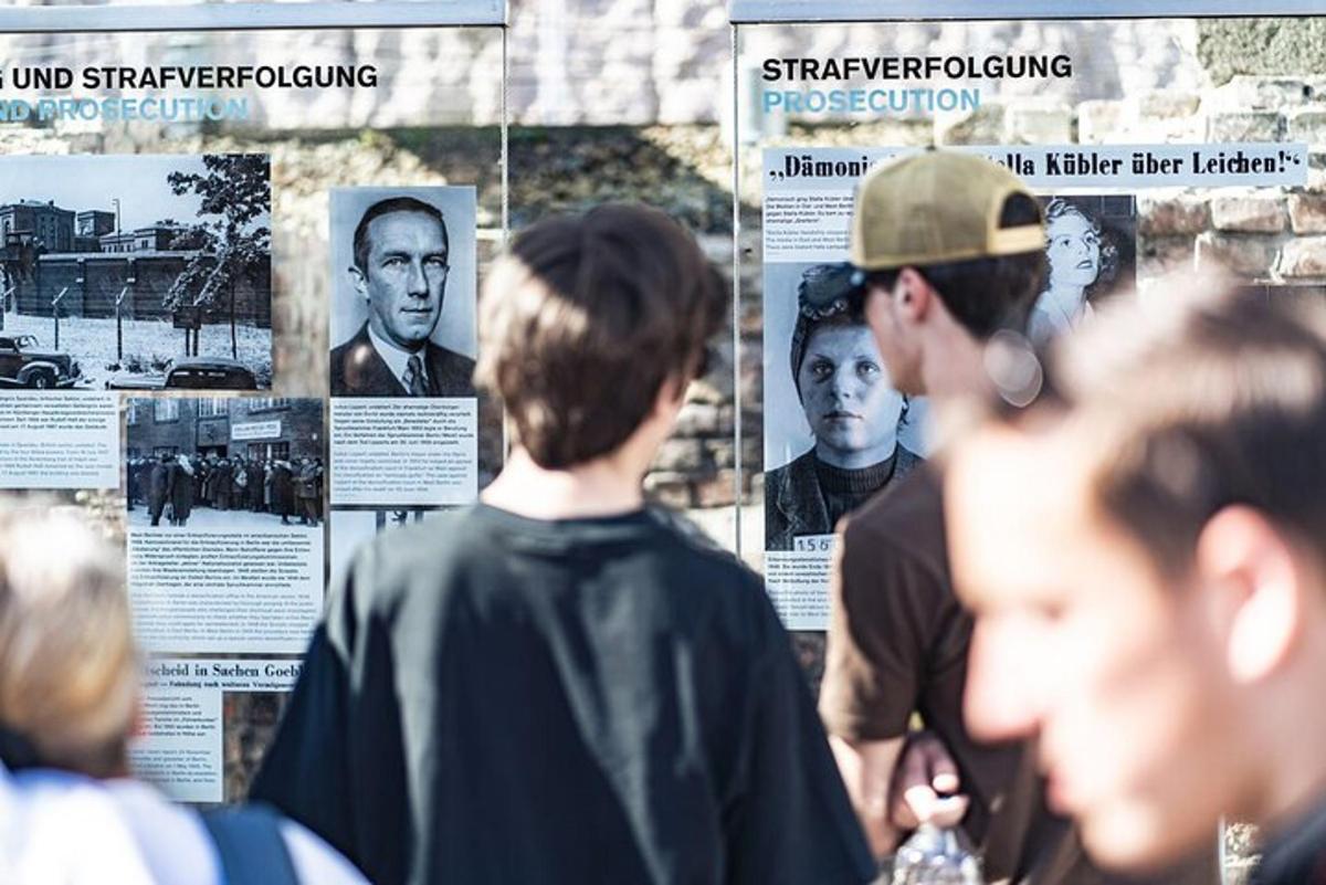 un gruppo di persone che guardano una mostra di fotografie