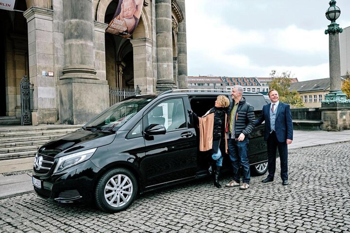 un gruppo di tre persone in piedi accanto a un'auto