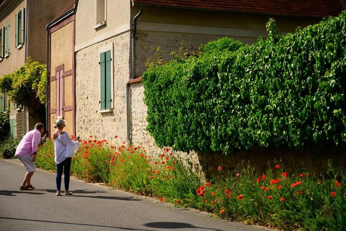 two people walking down a street next to a building