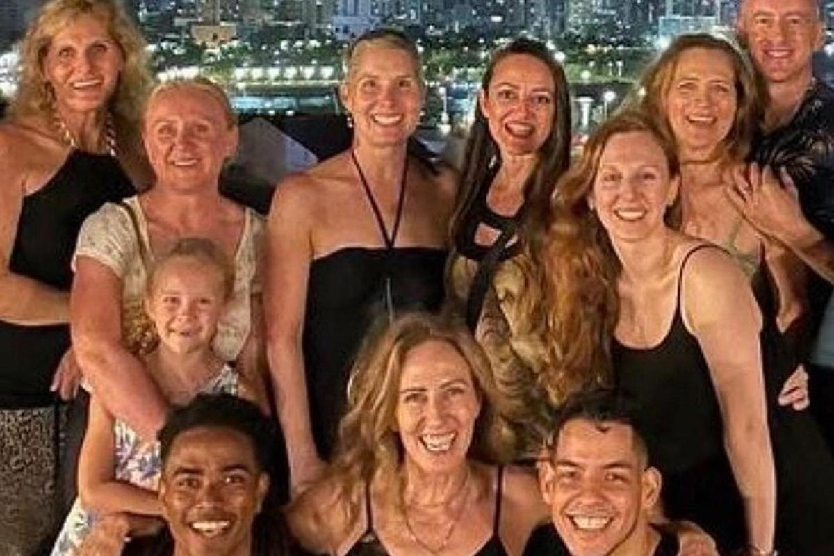 um grupo de pessoas posando para uma foto em frente a uma cidade