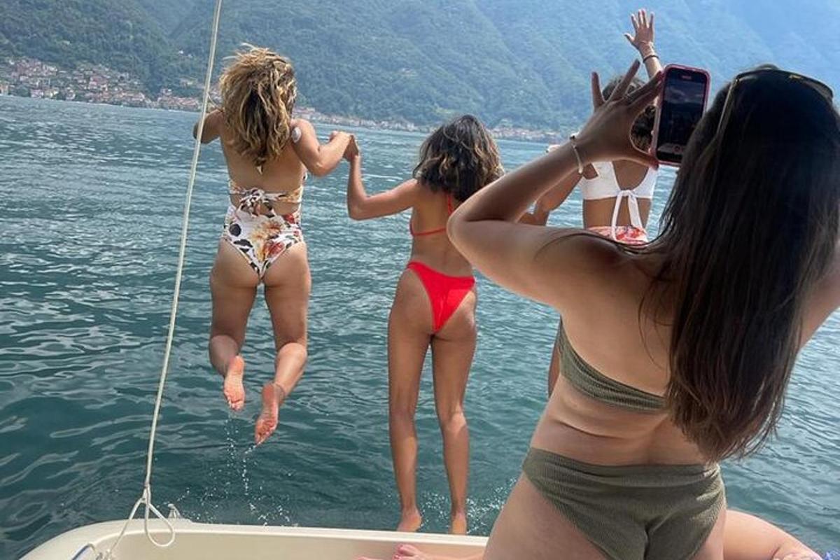 Tres chicas saltando de un bote en el agua