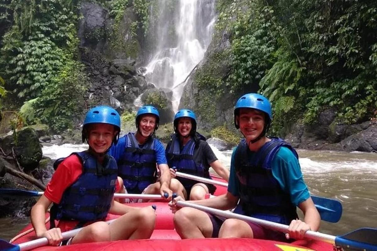 um grupo de pessoas em uma jangada em frente a uma cachoeira