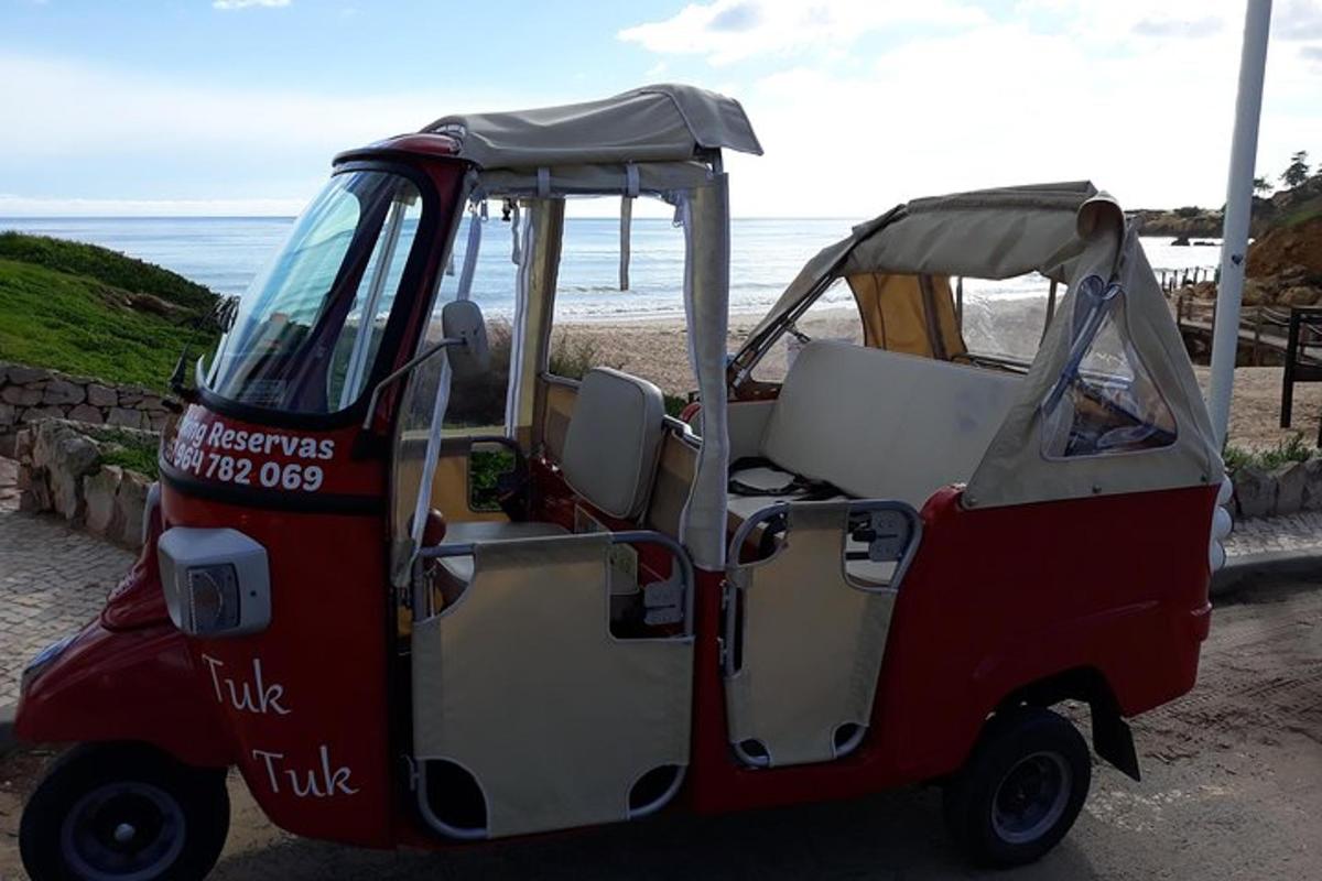 một chiếc xe golf màu đỏ và trắng đậu trên bãi biển