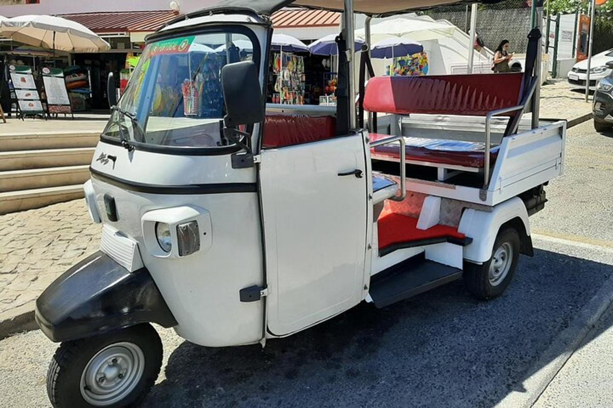 một chiếc xe golf nhỏ có ghế màu đỏ trên phố