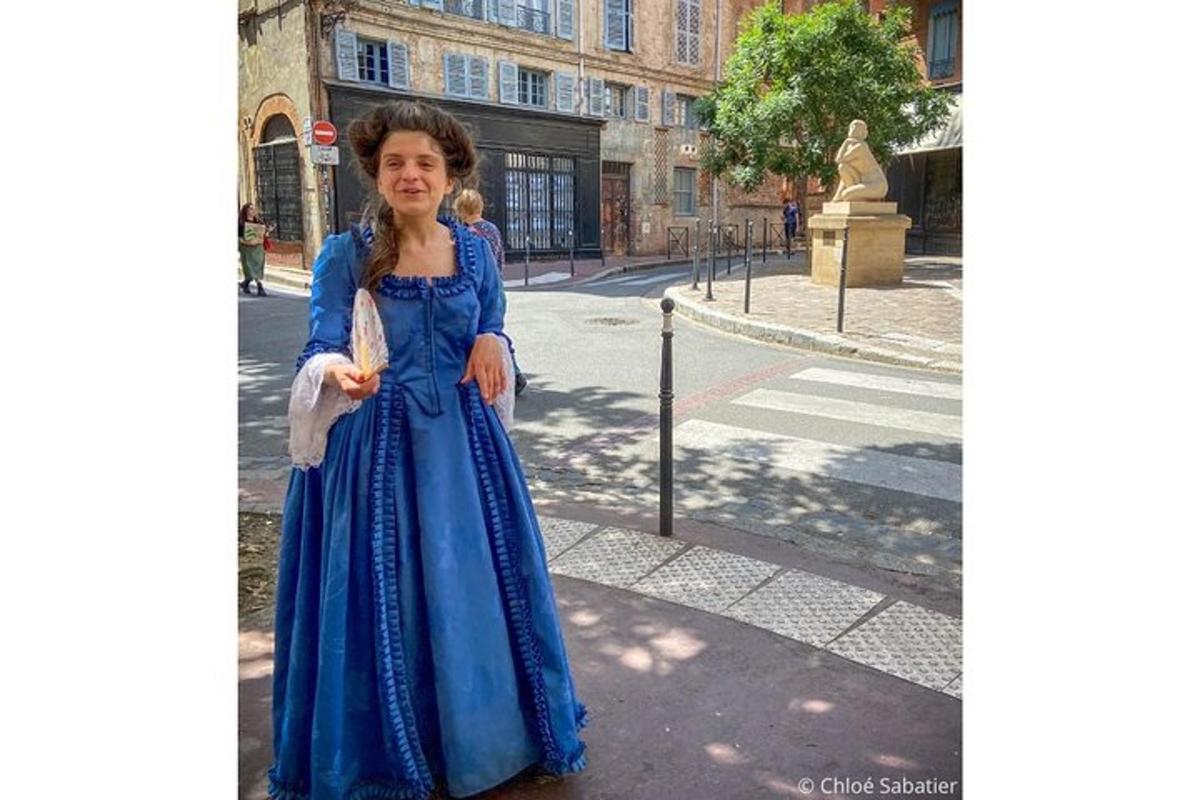 una giovane ragazza in un vestito blu in piedi su una strada