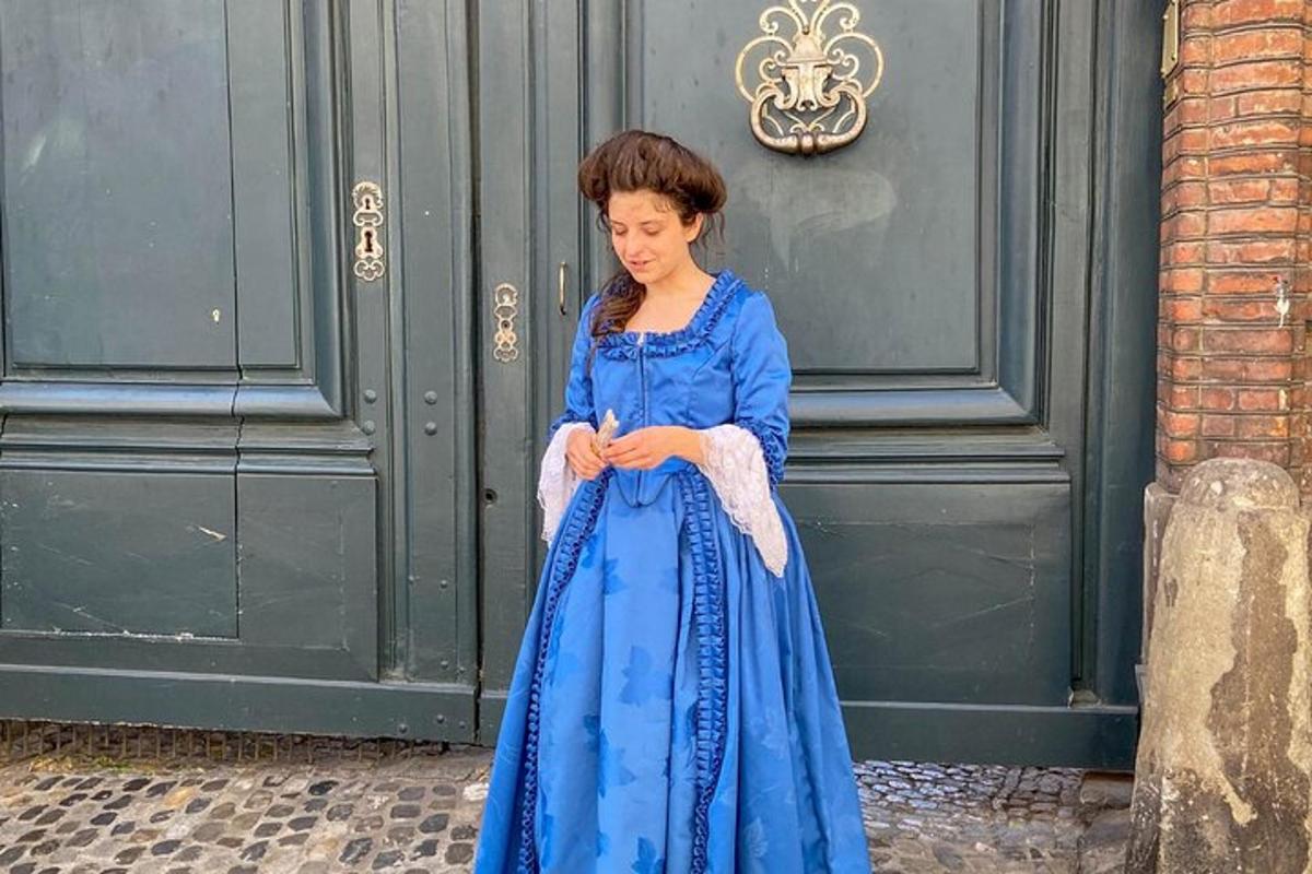 una donna in un vestito blu seduta per strada